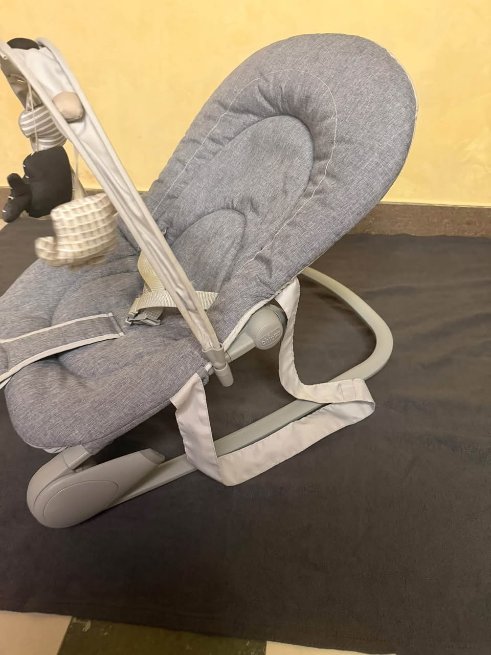 Grey baby bouncer chair with toys