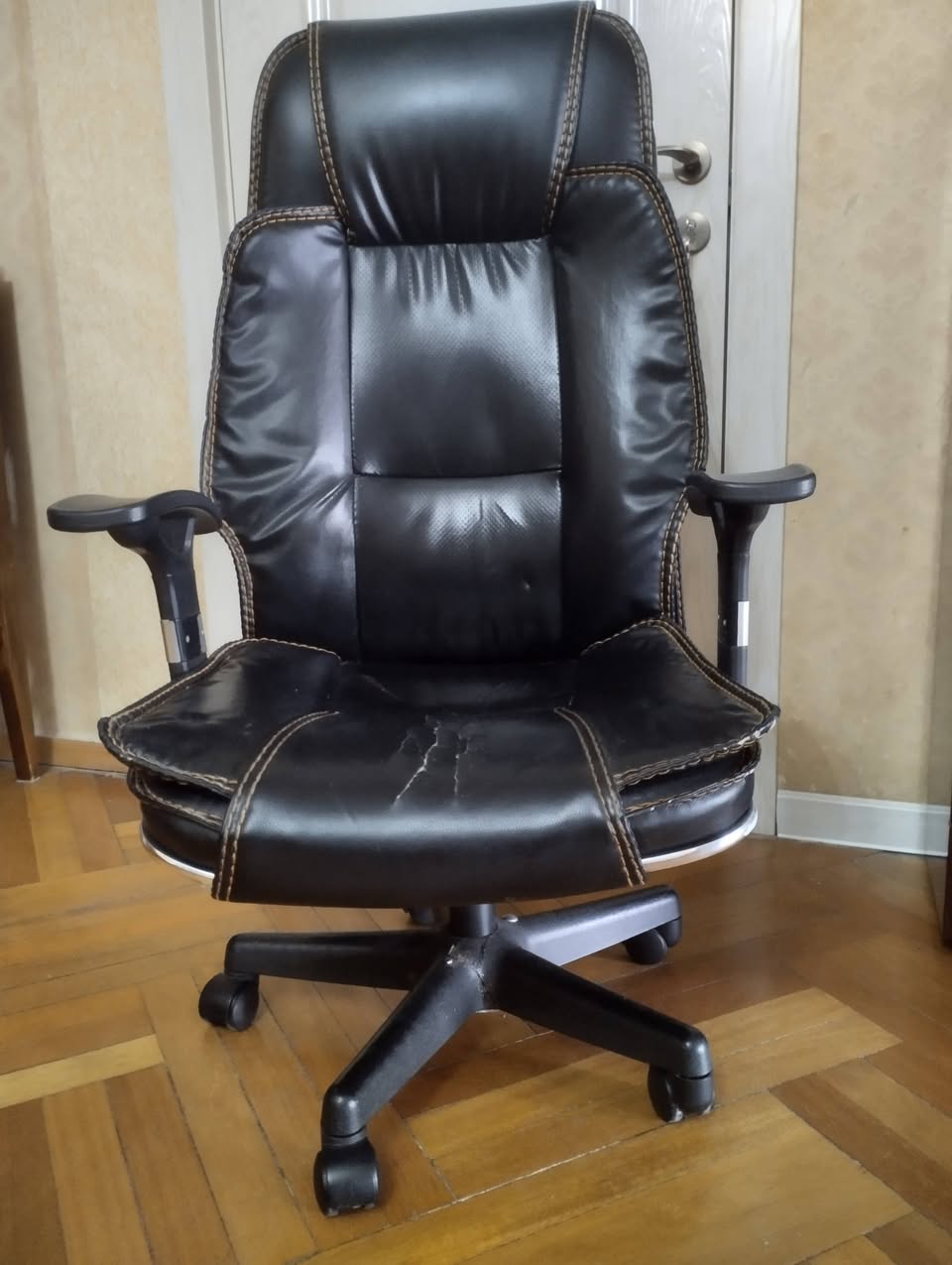 Black leather office chair with armrests