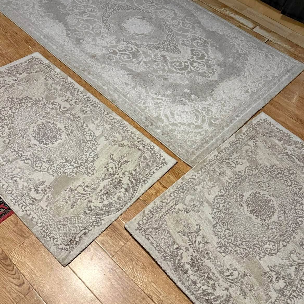 Set of three cream patterned rugs